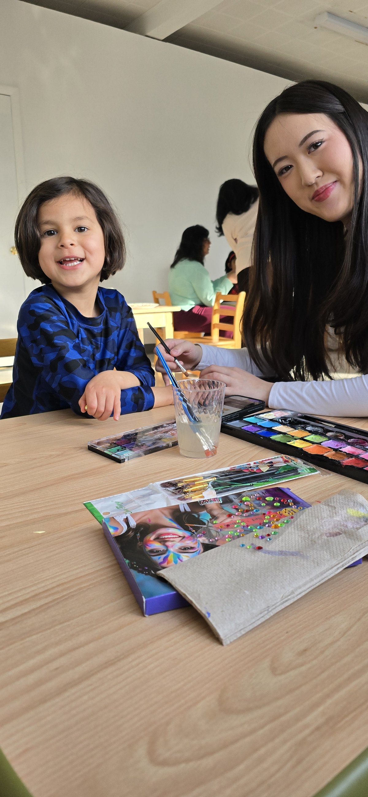 Child and parent painting together at a Milestones art event
