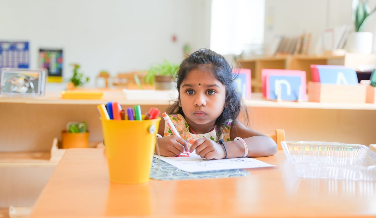 Two children working side by side on Montessori materials