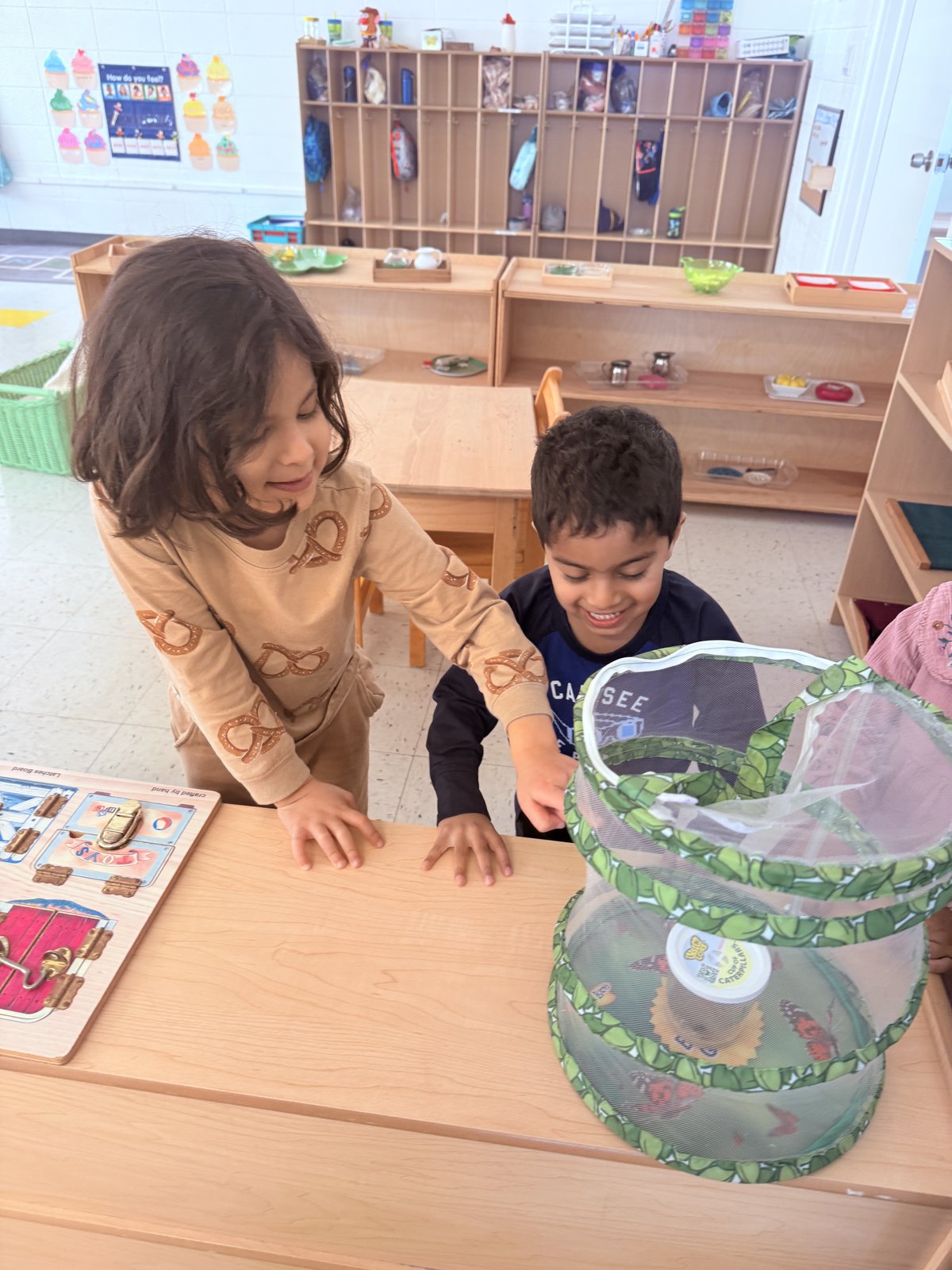 Student proudly displaying completed artwork in classroom