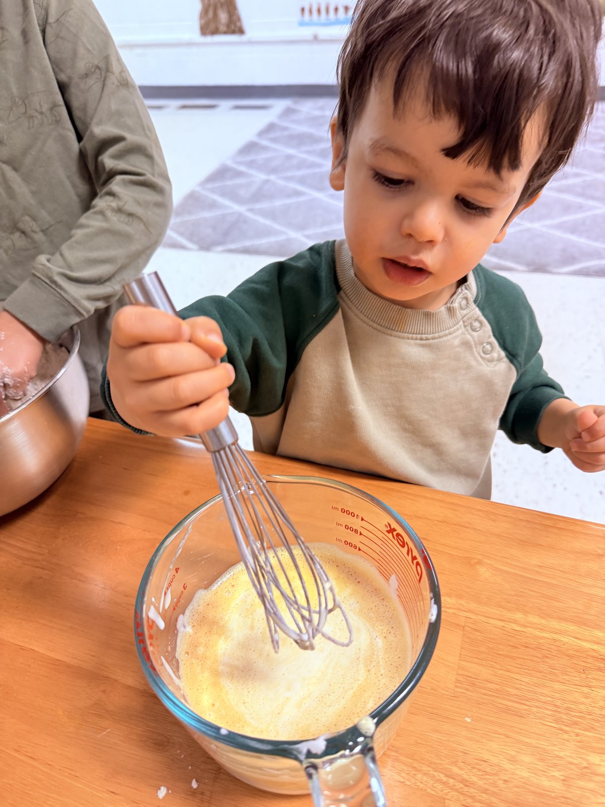 Child whisking and mixing in a practical life cooking activity