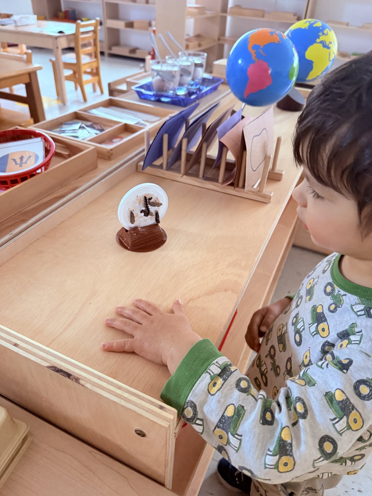 Student proudly showing a completed Montessori art piece